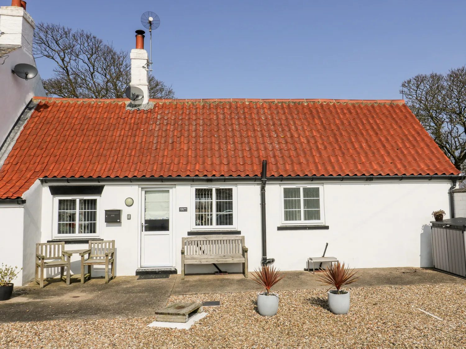 The front of The Old Joiner's Shop, a white cottage with a red tiled roof