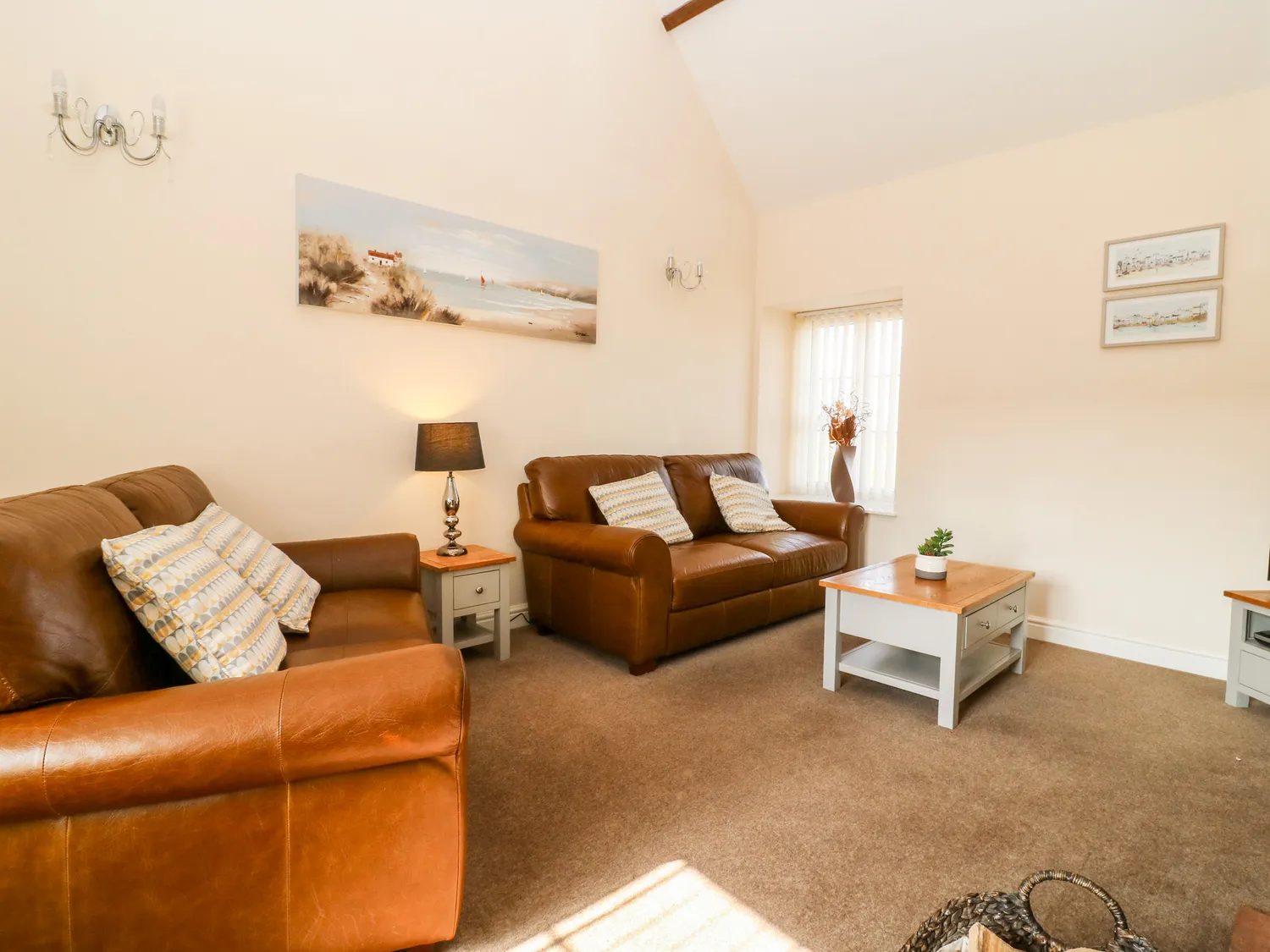 The sitting room with leather sofas under a vaulted ceiling